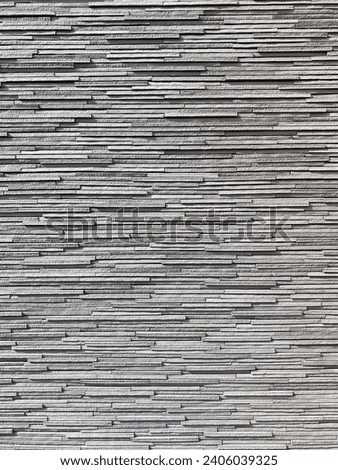 Thin stone slab texture background. Rocky facade veneer. Grey slivers of rock forming a layered wall. Drop shadow 3D style lighting.