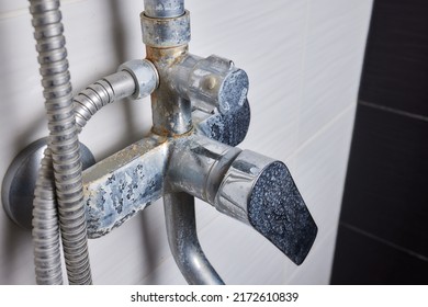 A Thin Stream Of Hard Water Flows From An Old Tap Aerator. Old Bathroom Sink Faucet Contaminated With Calcium And Grime.