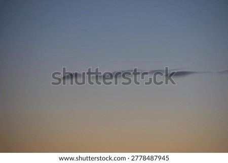 Thin, stringy clouds on a somber, quiet evening