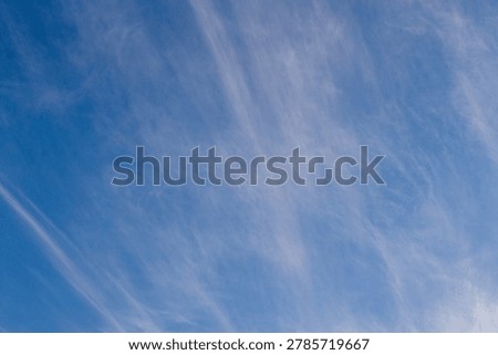 Thin stripy white clouds in a clear blue sky over southern Africa image in horizontal format for background use