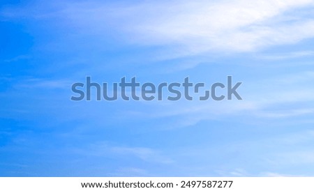 Thin white cloud streaks on bright blue sky background 