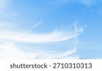 Thin white clouds blown by the wind in a beautiful blue sky on a windy summer day.
