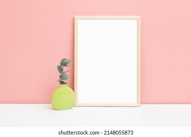 Thin Wooden Frame With A Small Vase And A Sprig Of Eucalyptus. Elegant Frame Mockup. Minimalistic Template For Your Design.