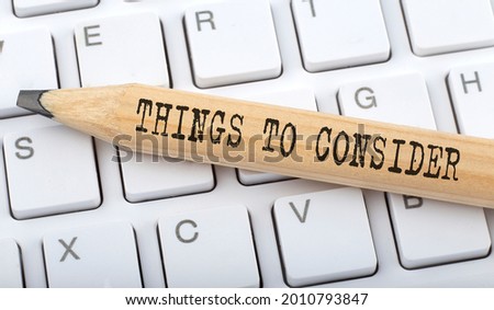 THINGS TO CONSIDER text on pencil on keyboard background