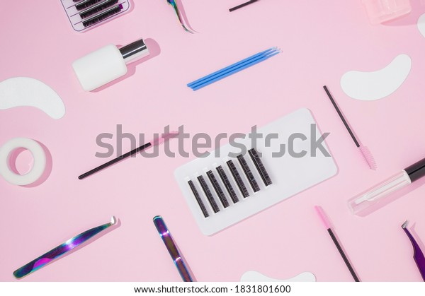 Things for the work of lash-makers,\
artificial eyelashes, microbrachis, glue, tweezers, combs, brushes\
for eyelash extensions. Eyelash extension, painting of eyebrows.\
Top view, pink\
background.