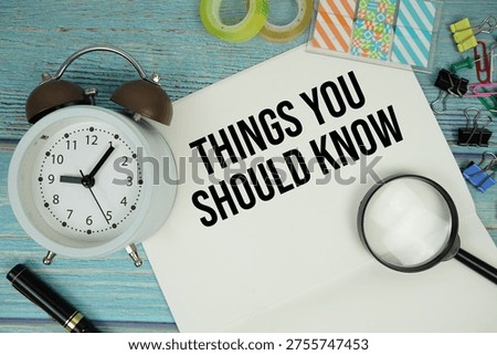 Things You Should Know text written on notepad with alarm clock and magnifying glass flat lay on wooden background