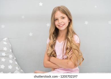 Things you shouldnt do at night if you want healthier hair. How to style hair before go to bed. Girl with long curly hair grey background. Hair care tips. Easy way keep nice hairstyle.