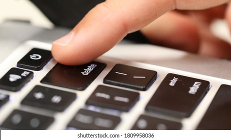 Think before posting. A close up of a finger about to push the delete key on a computer keyboard. Online cyber bullying social media trolling abuse concept. Deleting your history, cancel culture idea