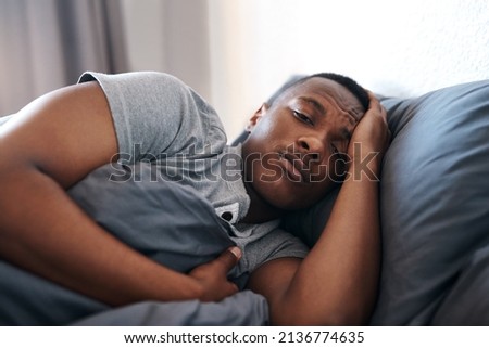 I think Ill just lay here all day. Cropped shot of a handsome young man lying in bed and feeling depressed while home alone.