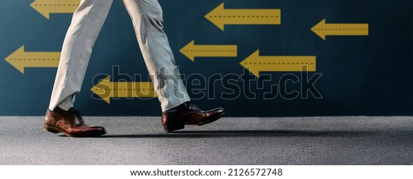 Think and Make the Different Concept. Unique\
Leadership. Businessman Walking Conversely the Arrow Direction.\
Different from Others. Low Angle\
View