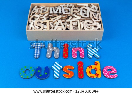 Think outside the box with a box full off dull mixed letters saying humdrum and static with a creative colourful patterned message on a blue background