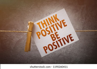 Think positive be positive paper note attach to rope with clothes pins