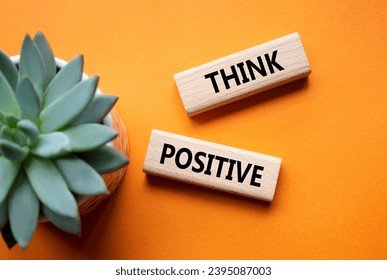Think Positive symbol. Concept word Think Positive on wooden blocks. Beautiful orange background with succulent plant. Business and Think Positive concept. Copy space - Shutterstock ID 2395087003