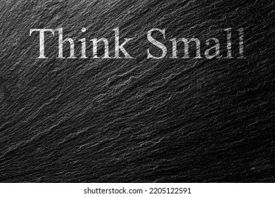 Think Small Chalk Text On Black Stone Slab