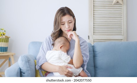 Thinking Asian mom and baby at home - Shutterstock ID 2042077550
