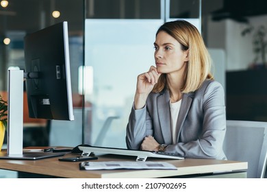 Thinking business woman looking at computer monitor, business woman working in modern office, planning new project, and business strategy - Powered by Shutterstock