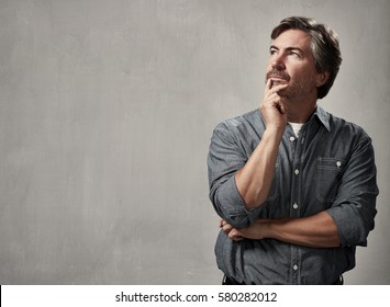 Thinking caucasian man portrait over gray wall background