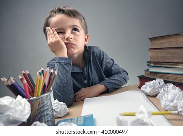 Thinking child bored, frustrated and fed up doing his homework