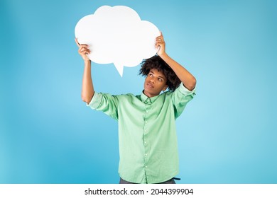 Thinking Concept. Pensive African American Guy Holding And Looking At Speech Bubble, Pondering, Posing On Blue Background, Free Space For Text. Thoughtful Male Student With Empty Word Cloud