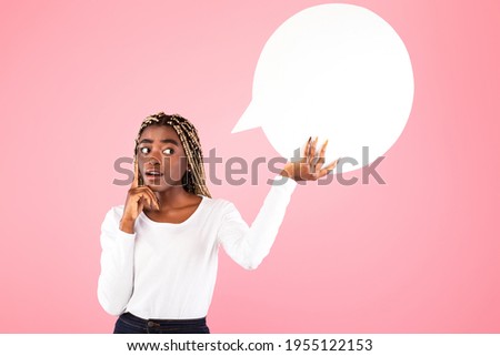 Thinking Concept. Pensive black lady with afro braids holding and looking at speech bubble, pondering, posing on pink color background, space for text. Thoughtful woman with empty word cloud
