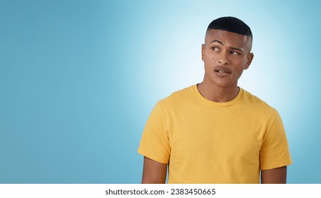Thinking, confused or problem solving and a man on a blue background in studio with a question on mockup. Doubt, idea or why with a young person on space for planning or brainstorming a solution