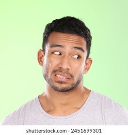 Thinking, crazy and face of man with doubt in studio on pastel green background with awkward feedback. Confused, question and embarrassed person with puzzle, challenge or conflict in mock up space