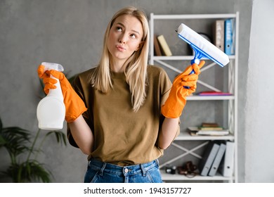 Thinking European Woman Posing With Streak And Cleaning Spray At Home