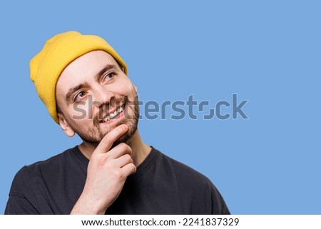 Thinking guy looking up and around on blue background. Pensive confused guy leaning hand, rubbing beard while thinking over difficult choice, People sincere emotions, lifestyle concept.