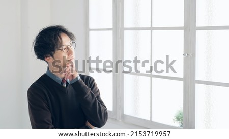 Thinking handsome Asian man in the room.