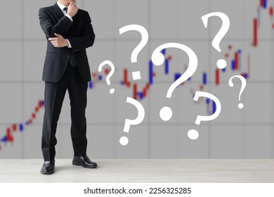 Thinking investor and question marks on stock chart background - Shutterstock ID 2256325285