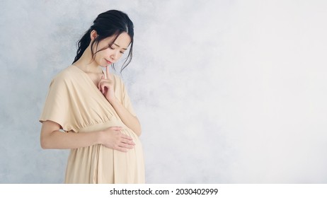 Thinking Pregnant Asian Woman Concept. Maternity Melancholy.