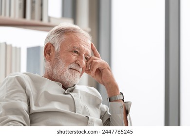 Thinking senior man sits on a couch in the living room, Elderly man thinks and sit on the sofa - Powered by Shutterstock