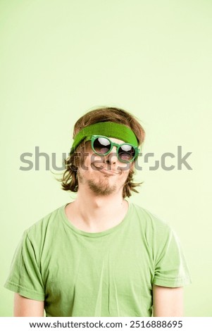 Thinking, sunglasses and face of man in studio with funny, comic or goofy facial expression. Thoughtful, comedy and portrait of crazy male model with silly personality isolated on green background
