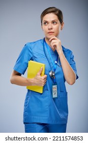 Thinking Teacher Doctor Or Student In Medical Suit With Yellow Book Looking Away. Isolated Portrait.