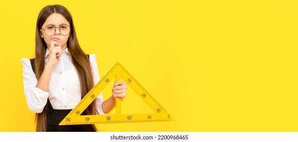 Thinking Teen Girl In Uniform And Glasses Hold Mathematics Triangle For Measuring, Measurement. Banner Of Schoolgirl Student. School Child Pupil Portrait With Copy Space.