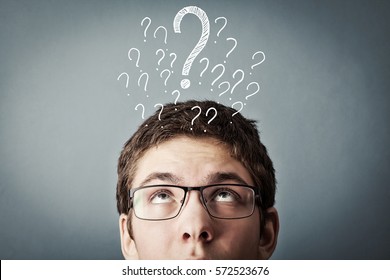 thinking teen with many question marks above his head, against grey background