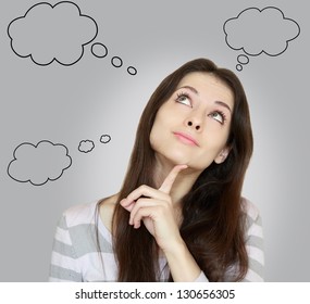 Thinking woman with many ideas in empty bubble on grey background looking up with finger at face - Powered by Shutterstock
