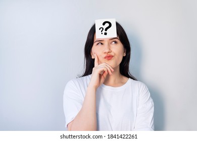  mujer pensante con signo de interrogación sobre fondo de pared gris