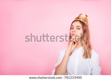 Thinking young woman in crown on pink background 