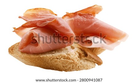 Thinly sliced prosciutto ham folded on a piece of crusty rustic bread