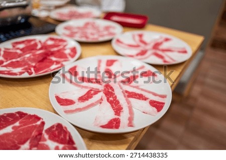 Thinly sliced raw beef prepared and served on plate for hot pot and shabu shabu cooking.