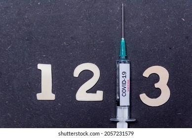 Third Covid Vaccine Dose And Jab Concept With Numbers. Syringe Is Seen On Table As A Concept For The 3rd Covid-19 Vaccine Dose, Also Called Booster Shot