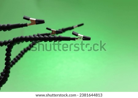 Third hand device for soldering clips holder on green background