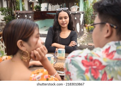 Third Party With Folded Arms Awkwardly Looks At A Couple Waiting For A Chance To Join The Conversation. Third Wheel Concept.