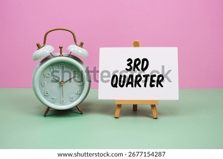 Third Quarter text with alarm clock on pink and green background