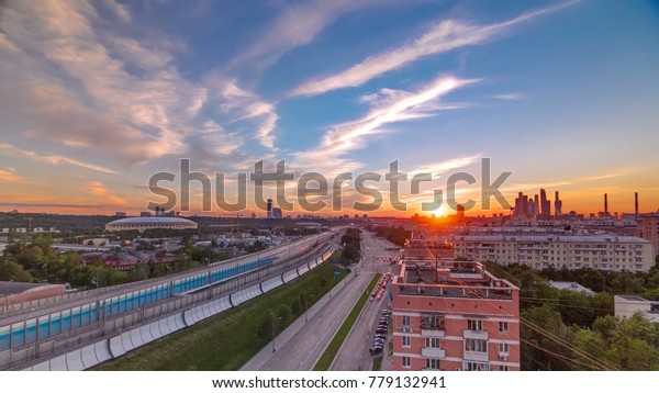 The Third Ring Road traffic at sunset timelapse\
aerial view from rooftop. Skyscrapers and stadium on background.\
The Third Ring is Moscow\'s newest beltway, located between the\
Garden Ring in the city