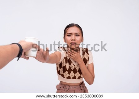 A thirsty asian woman desperately reaches out to someone holding a cup of water. A lady pleading for a drink. Isolated on a white background.