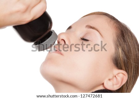 Thirsty Caucasian woman hydrating from a water bottle, close up