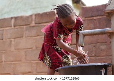 Thirsty Little African Girl Drinking Clean Fresh Water From The Village Borehole