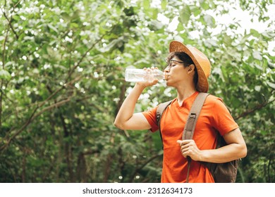 Thirsty man drinking water while hiking by forest. - Powered by Shutterstock